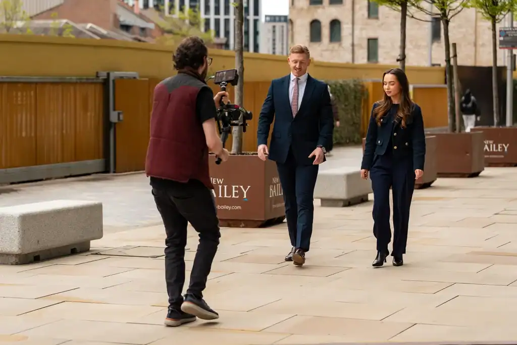 Filming a professional interview outdoors with a camera operator capturing two business professional.