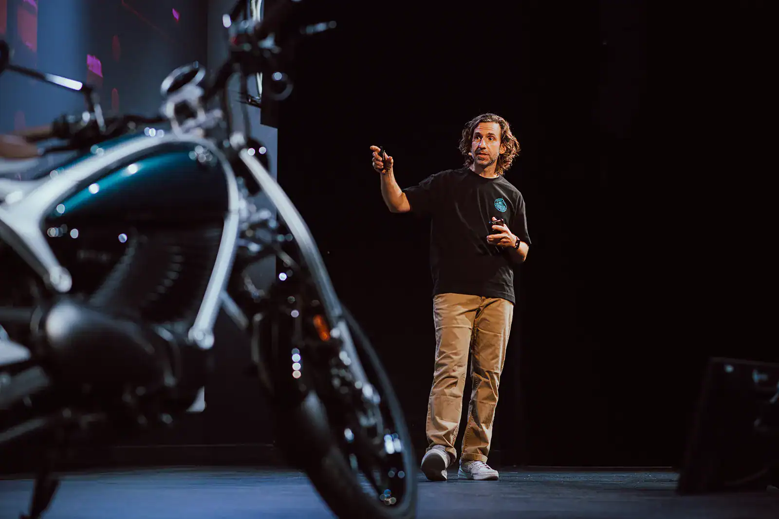 man presenting the flying flea by royal enfield on stage in paris